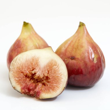 Beyaz arka planda dilimlenmiş taze incirler.