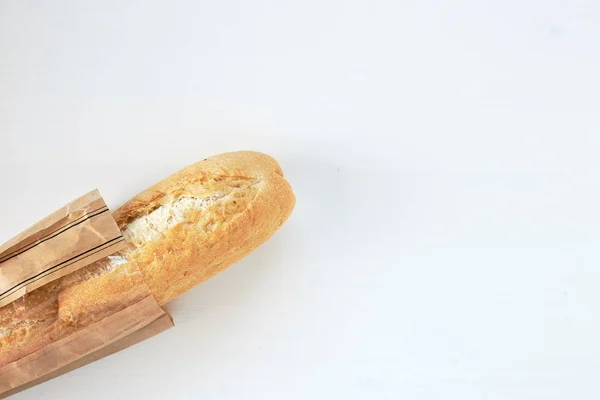 Baguete de pão francês em uma mesa fundo branco — Fotografia de Stock