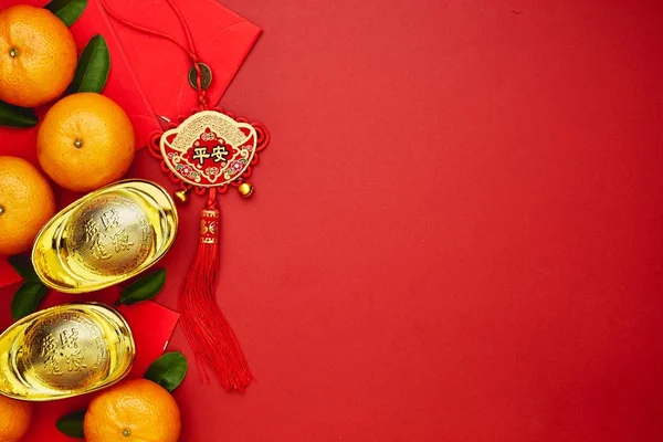 Chinese coins of luck or chinese knot and Chinese gold ingots and Traditional chinese knot  (Foreign text means blessing) and Red envelopes and decoration with Fresh oranges on Red Paper background