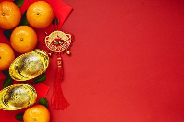 Şans ya da Çin düğüm ve Çin altın İngotlar ve geleneksel Çin düğüm (nimet yabancı metin anlamına gelir) ve kırmızı zarf ve dekorasyon kırmızı Kağıt arka plan üzerinde taze portakal ile Çin paraları