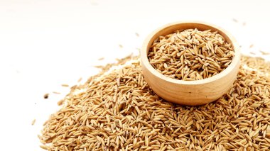 Çeltik tohumu beyaz arka plan üzerinde ahşap kase