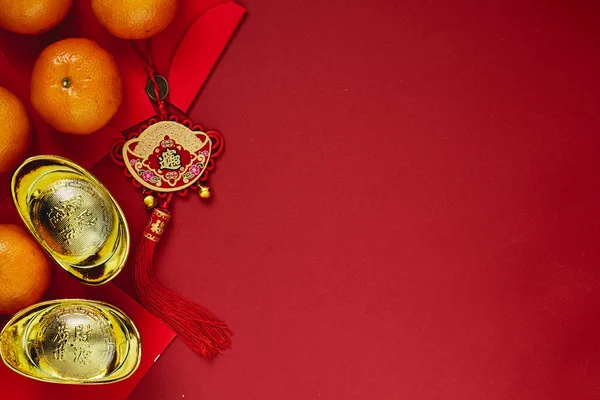 Chinese coins of luck or chinese knot and Chinese gold ingots and Traditional chinese knot  (Foreign text means blessing) and Red envelopes and decoration with Fresh oranges on Red Paper background