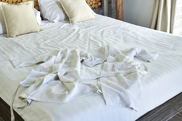 在床上的白色浴袍 — 图库照片