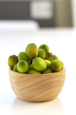 Beyaz bir arka plan üzerinde ahşap bir fincan Lotus tohum koymak