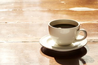 Tahta bir masada sıcak bir kahve.
