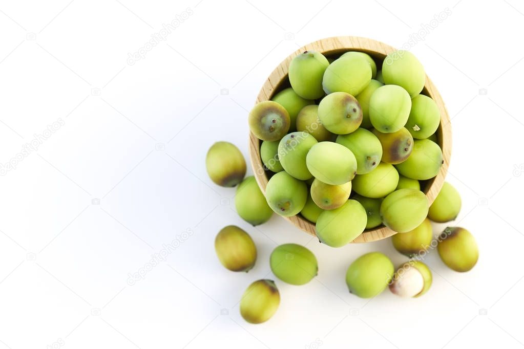 Lotus seeds put in a wooden cup on a white background