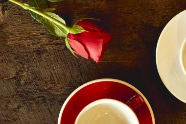 İki boş bardak kırmızı gül ile eski bir ahşap üstten görünüm üzerinde yer.
