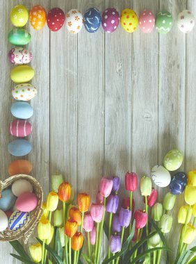Renkli Paskalya yumurtaları ve ahşap üzerine lale 
