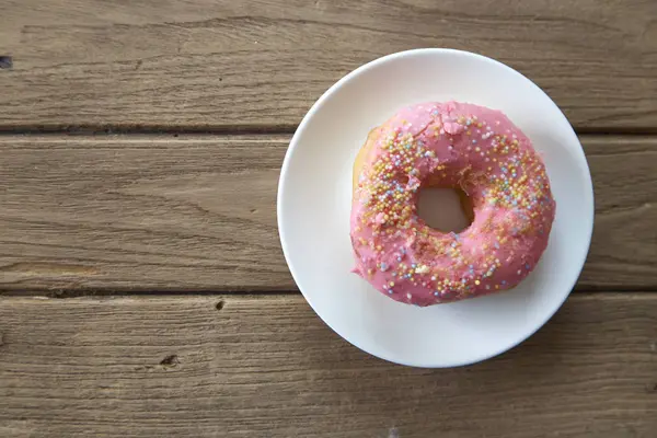 Pink donut on a plate — Stock Photo, Image