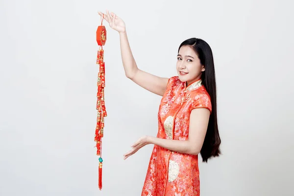 Hermosa chica en cheongsam rojo sosteniendo galletas de fuego — Foto de Stock