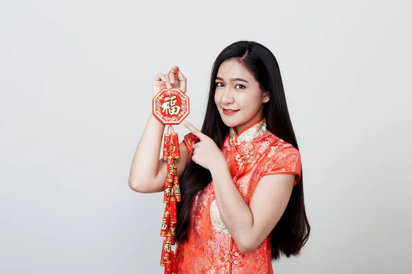 Hermosa chica en cheongsam rojo sosteniendo galletas de fuego — Foto de Stock