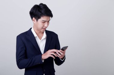 Genç Asyalı iş adamı akıllı telefon kullanıyor.
