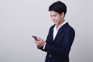 Genç Asyalı iş adamı akıllı telefon kullanıyor.