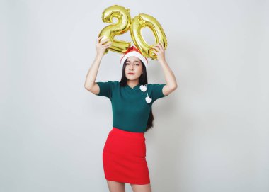 Metalik folyo balon numarası tutan çekici bir kadın.