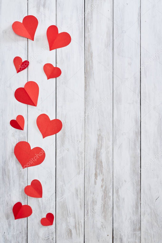 Red paper hearts on White wooden table