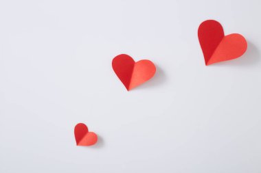 Beyaz arkaplanda kırmızı kağıt kalpler