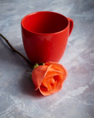 Masasında kırmızı boş kupa olan gül.