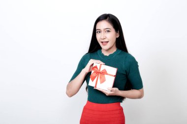Hediye kutusu tutan ve dişlek gülümseyen bir kadın.