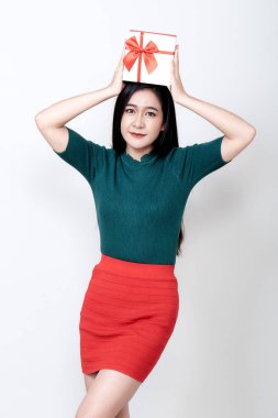 Hediye kutusu tutan ve dişlek gülümseyen bir kadın.