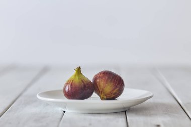 Beyaz ahşap bir tabakta incir