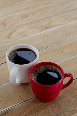 İki kırmızı ve beyaz kupa kahve tahtada