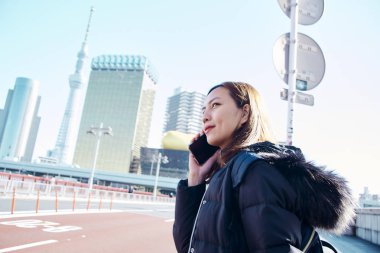 Tokyo Japonya 'da akıllı telefon kullanan kadın turist.