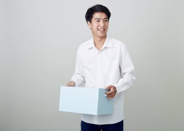 Genç Asyalı iş adamı elinde bir kutu tutuyor.