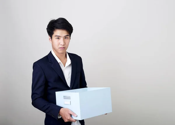 Young asian businessman holding a box — Stock Photo, Image