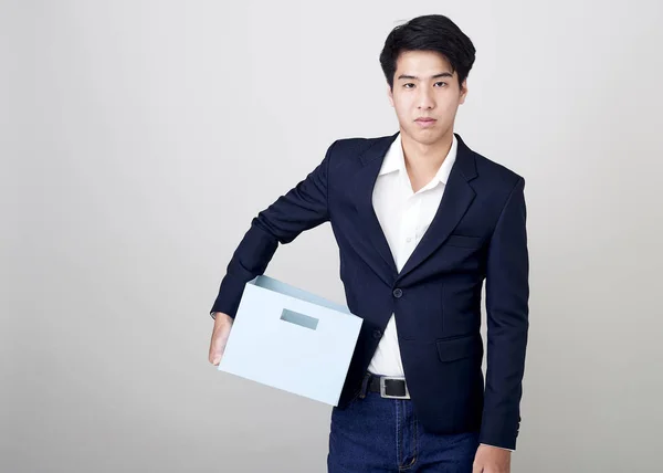 Young asian businessman holding a box — Stock Photo, Image