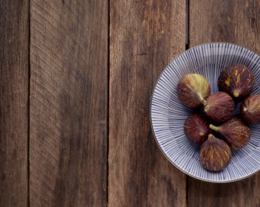 İncir ahşap masa arka plan üzerinde plaka üzerinde