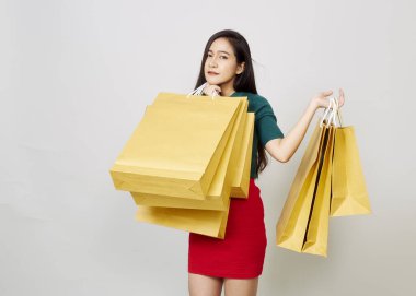 alışveriş torbaları tutan genç gülümseyen kadın