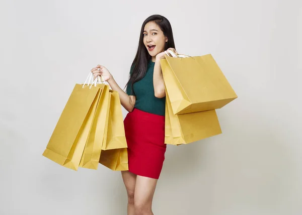 Alışveriş torbaları tutan genç gülümseyen kadın — Stok fotoğraf