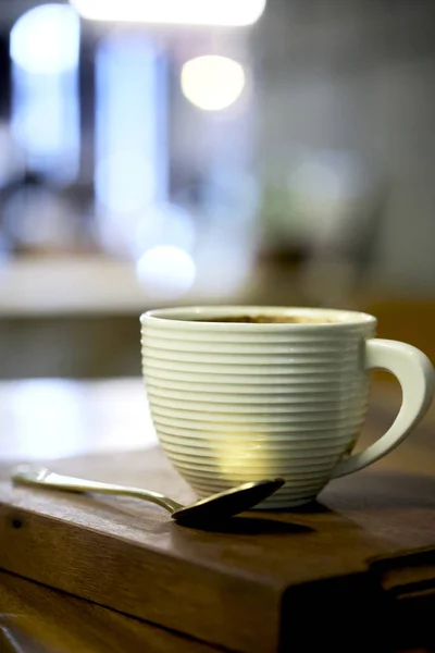 Horká káva na dřevěném stole v kavárně — Stock fotografie