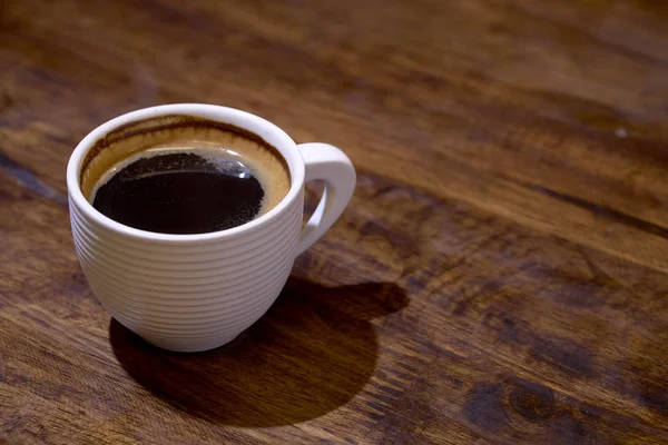 Xícara de café fresco em fundo de madeira — Fotografia de Stock