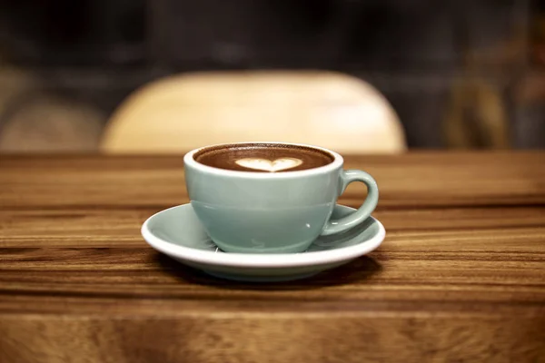 Tasse de café latte art sur bois — Photo