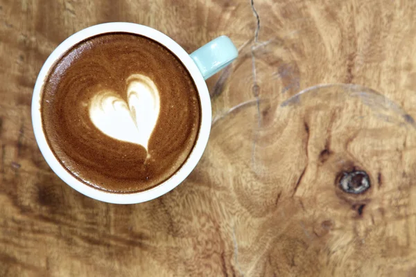 Mug of latte art coffee on wooden — Stock Photo, Image