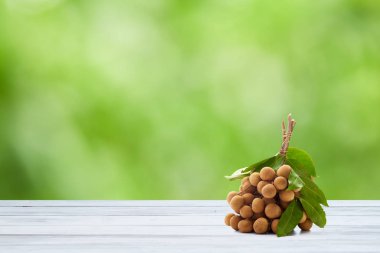 Ahşap masa yeşil bulanık ağaçlarla bokeh arkaplanlı, bahar ve yaz mevsimi