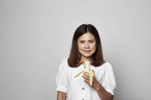 Νεαρή Ασιάτισσα Που Κρατάει Την Κίτρινη Μπανάνα Έννοια Της Σωστής — Φωτογραφία Αρχείου