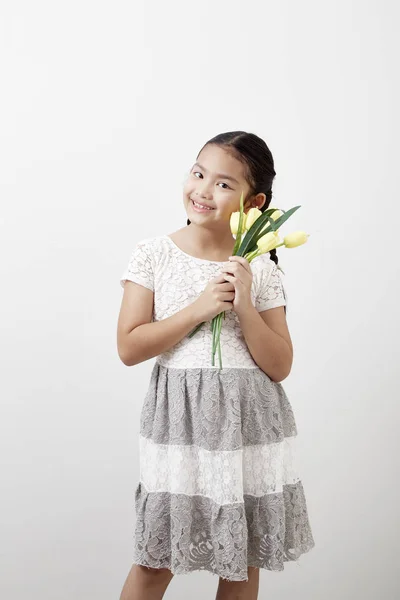 Азиатская Маленькая Девочка Держит Букет Желтых Тюльпанов Белом Фоне Концепция — стоковое фото