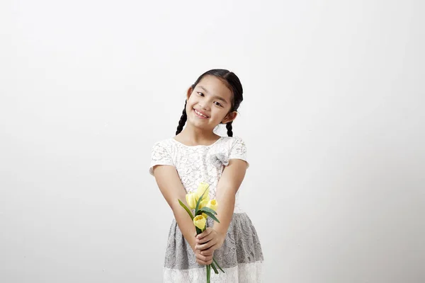 Asiatisches Kleines Mädchen Mit Einem Strauß Gelber Tulpen Auf Weißem — Stockfoto