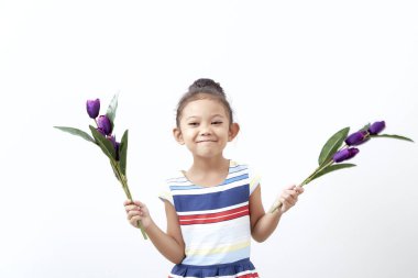 Portre Mutlu Asyalı şirin kız çocuk Paskalya günü beyaz arka planda buket mor lale tutuyor. Mutlu Paskalyalar