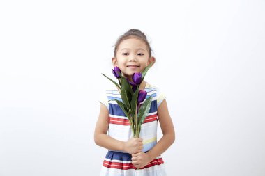 Portre Mutlu Asyalı şirin kız çocuk Paskalya günü beyaz arka planda buket mor lale tutuyor. Mutlu Paskalyalar