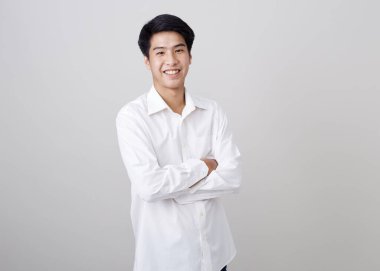 Duvardaki Asyalı yakışıklı iş adamının gri arka plan üzerindeki stüdyo fotoğrafı.