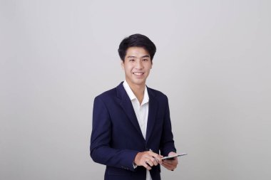 Beyaz arka plan, mimari, mühendislik, inşaat ve ev tasarımı konsepti üzerine not tutan şık takım elbiseli çekici genç işadamı..