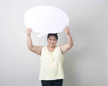 Metin stüdyosu için boş alanı olan, güler yüzlü şişman Asyalı kadının portresi açık gri bayrak arkaplanının karşısında tek başına çekilmiş.