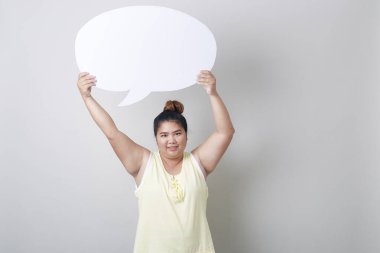 Metin stüdyosu için boş alanı olan, güler yüzlü şişman Asyalı kadının portresi açık gri bayrak arkaplanının karşısında tek başına çekilmiş.
