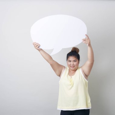 Metin stüdyosu için boş alanı olan, güler yüzlü şişman Asyalı kadının portresi açık gri bayrak arkaplanının karşısında tek başına çekilmiş.
