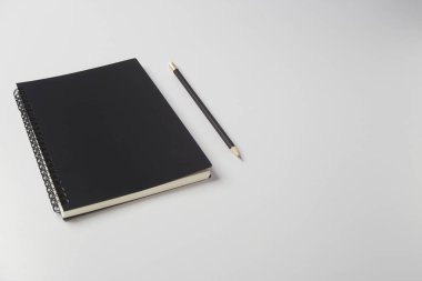 Beyaz arkaplanda kurşun kalemli Boş Siyah Günlük Yapılandırma Defteri