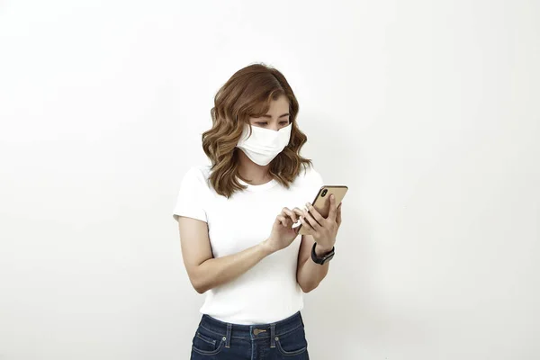 Thai Γυναίκα Φορώντας Μάσκα Προσώπου Χρησιμοποιώντας Smartphone Απομονώνονται Φωτεινό Γκρι — Φωτογραφία Αρχείου