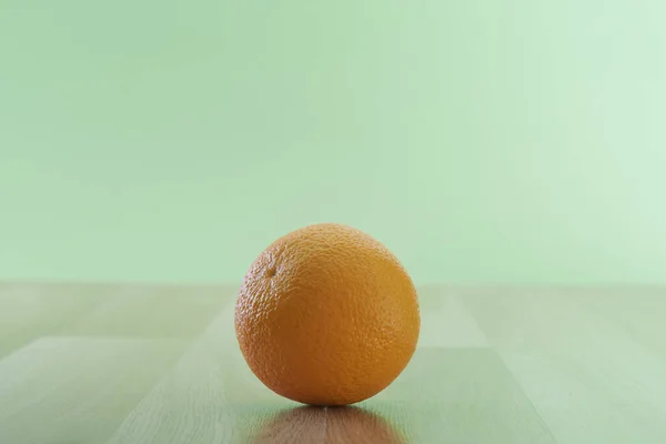 緑の壁の背景に隔離された木製のテーブルの上に新鮮なオレンジの果物 テキストのためのコピースペース — ストック写真